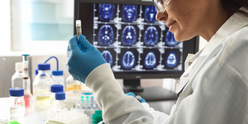 A woman in a lab coat is analyzing a data repository on her computer screen.