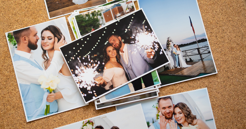 A group of wedding photos on a cork board.