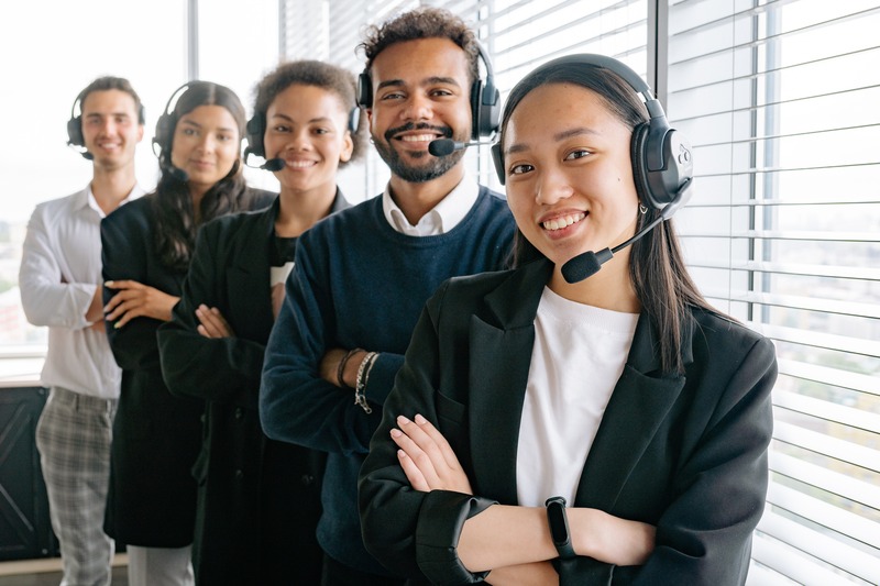 A group of people standing in front of a window in a call center.