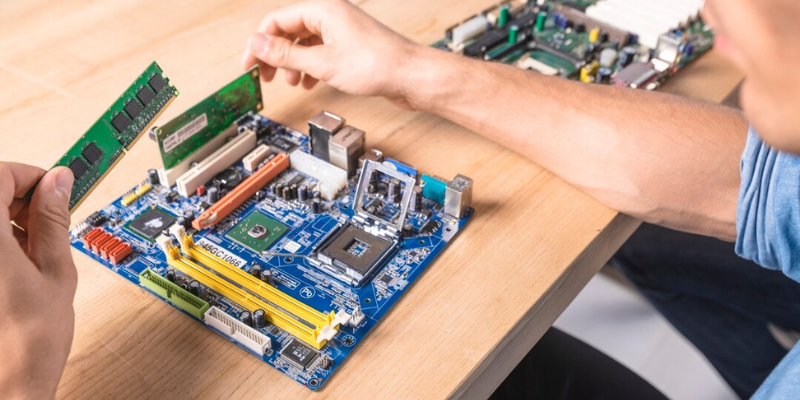 A man is working on a computer motherboard.