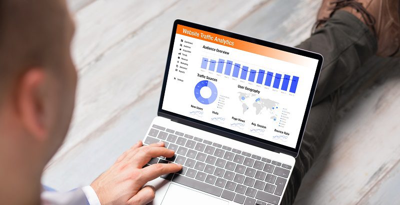 Man viewing website traffic analytics data on laptop computer