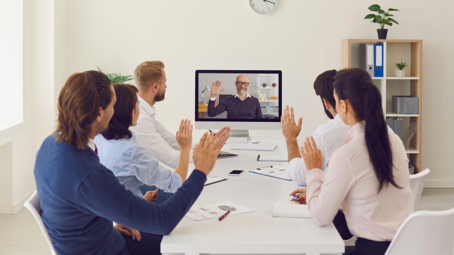 A group of people utilizing an AI Meeting Assistant at a conference table.