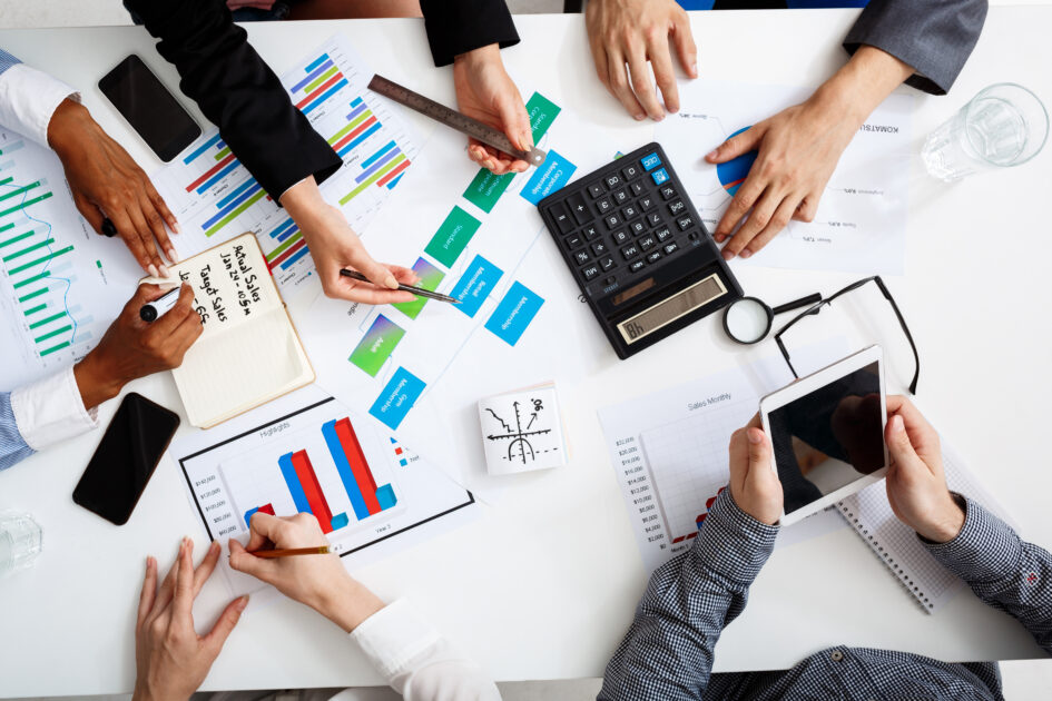 Picture of businessmen's hands on white table with documents and drafts