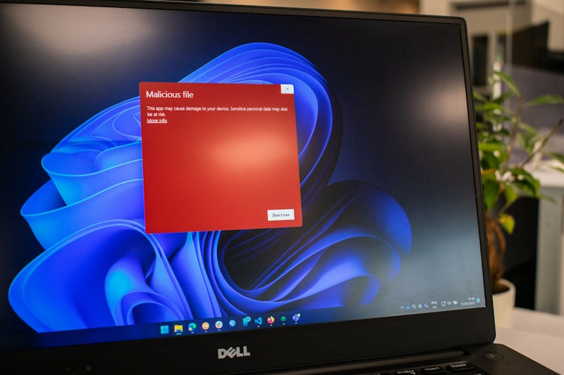 A laptop is showing a notification for a malicious file