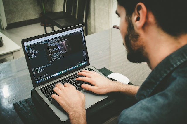 A developer writing code on his laptop