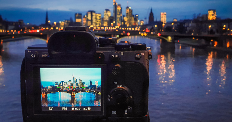 A camera is taking a picture of a city at night.