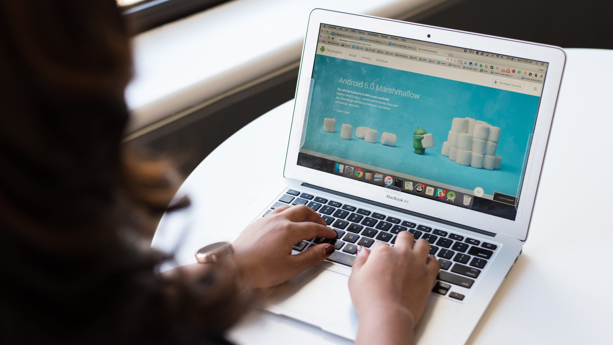 A woman is using a laptop to view a landing page.