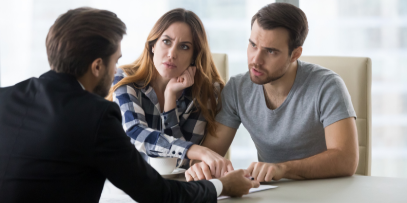 A couple engaged in conversation at a table as a part of the complaint management system.