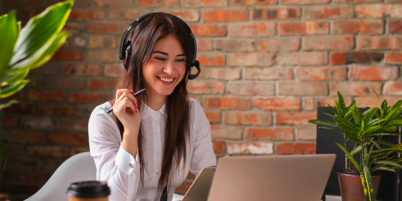 A woman wearing a headset and sitting at a desk.