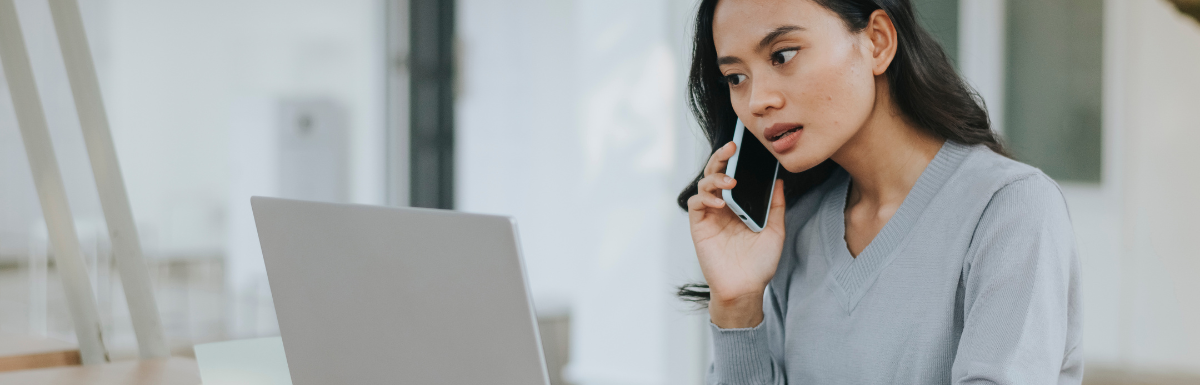 A woman utilizing voice call APIs while sitting in front of a laptop.