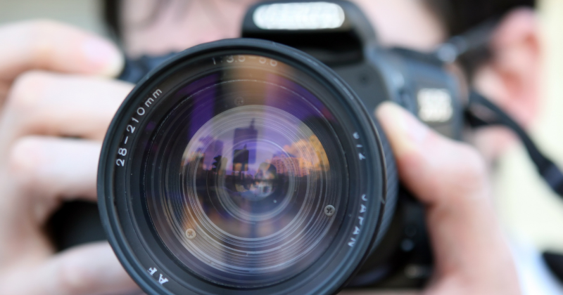 A person is taking a picture with a camera lens.