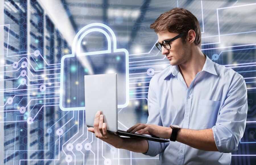 A man is using a laptop in a data center.