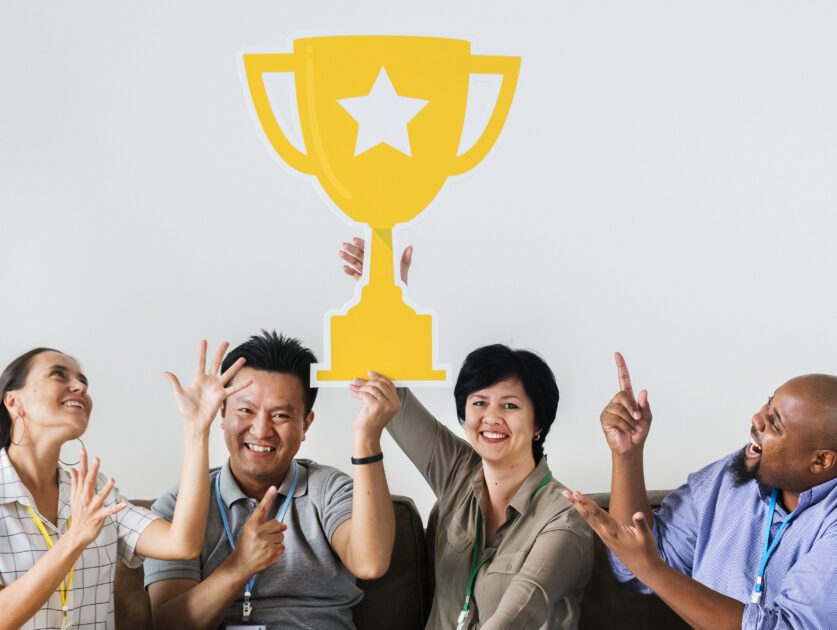 Workers celebrating their success with a trophy