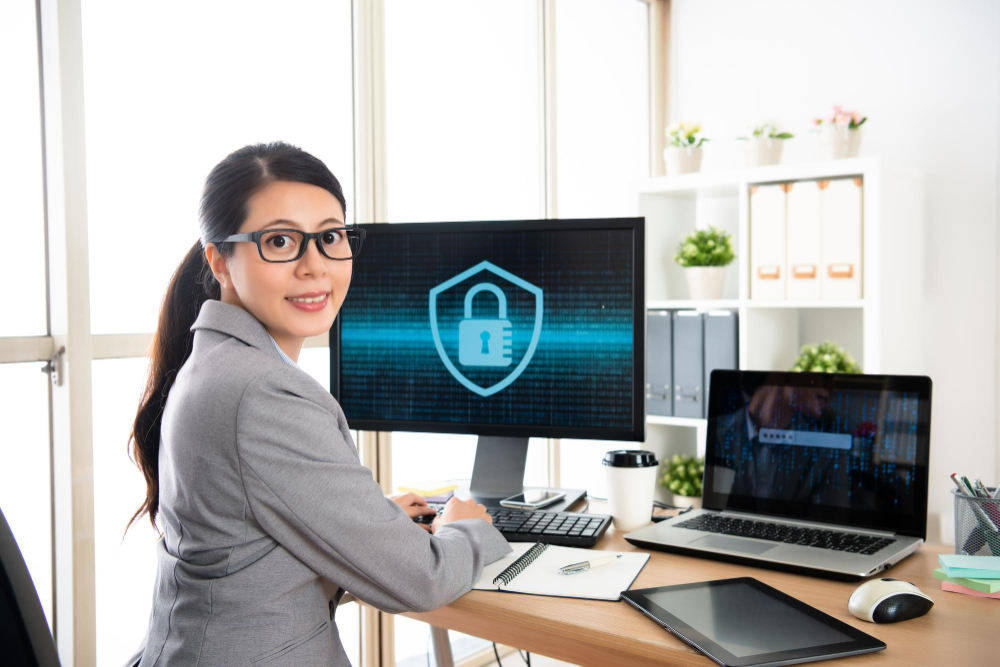 A woman sitting at a desk with a laptop and a padlock on it.