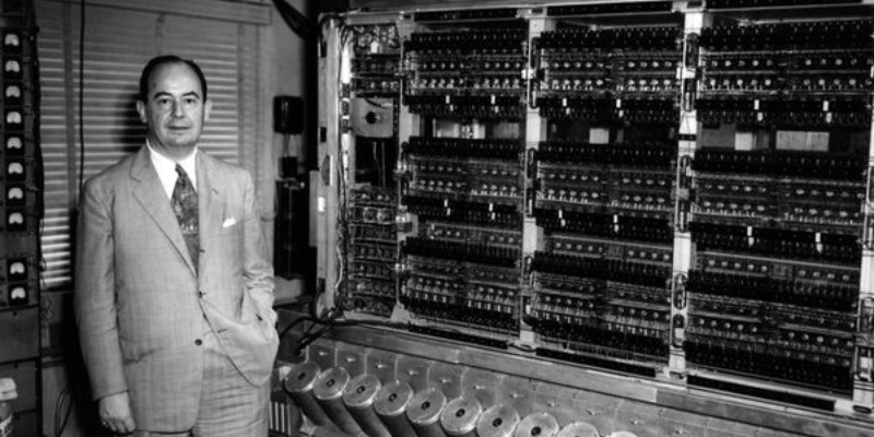 A man in a suit standing in front of a machine.