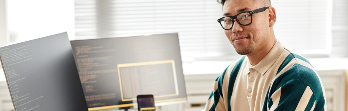 A man in glasses sitting in front of a computer.