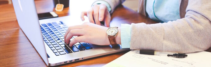 Fingers Typing on the Keyboard of the Laptop