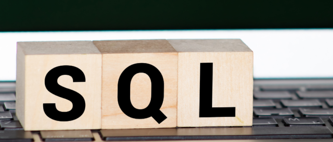 A wooden block with the word SQL on top of a keyboard, representing SQL views.