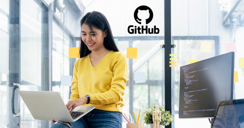 A woman sitting in front of a laptop with the word github on it.