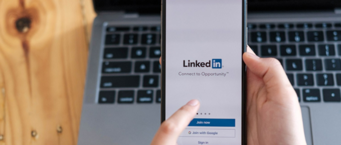 A person holding an iPad connected to a LinkedIn post generator.