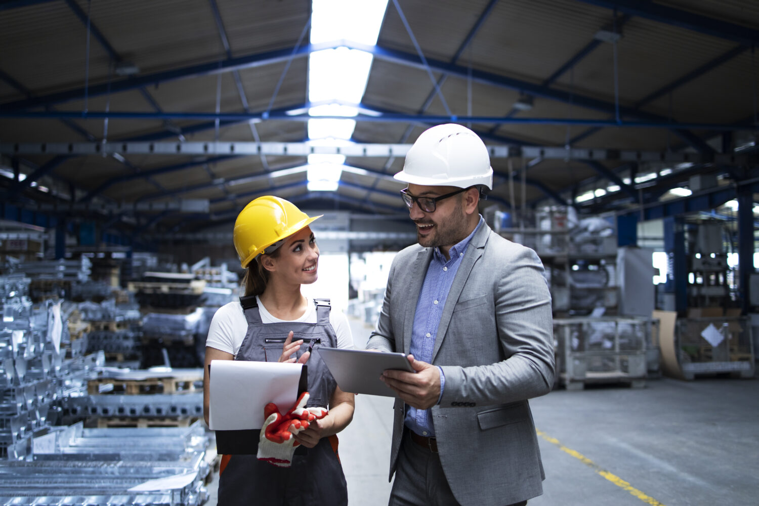 Manager supervisor and worker discussing about production results and new strategy in factory industrial hall.