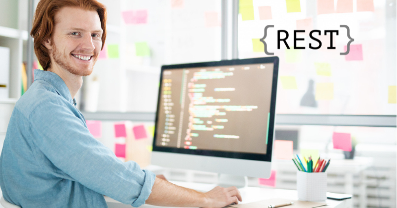 A man sitting in front of a computer with the word rest on it.