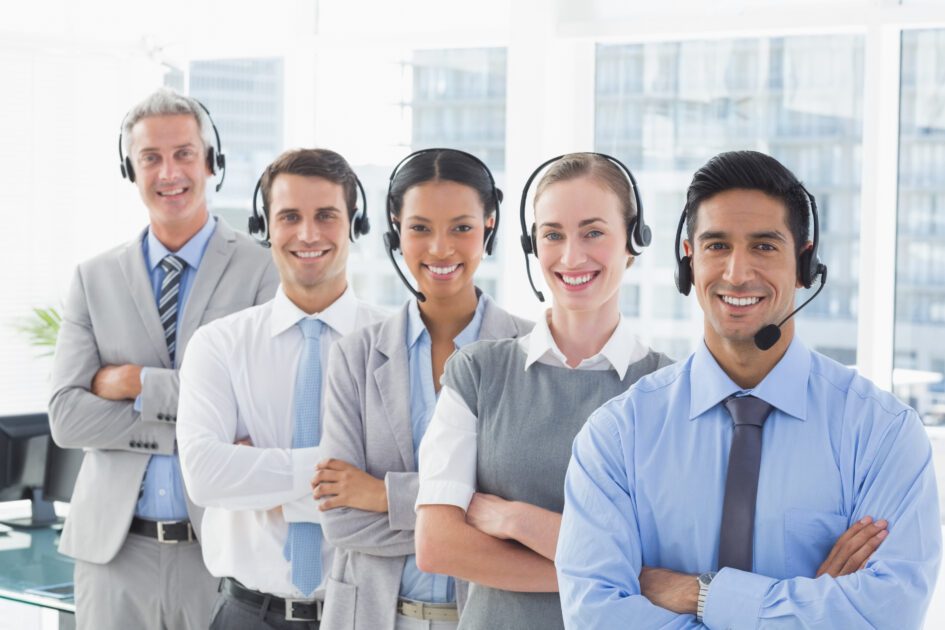 Business people with headsets smiling at camera in office