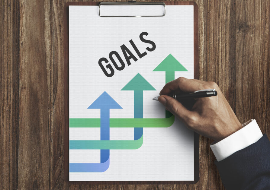 Hands Writing Business Plan on the Sheet