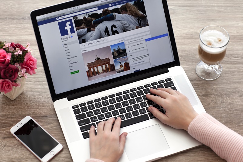 Woman with MacBook and iPhone with social networking service Twi
