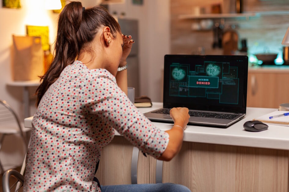 A lady sitting at a desk looking at a laptop