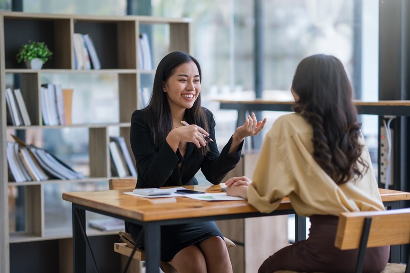 Two happy asian businesswoman talking and consulting working together in the office